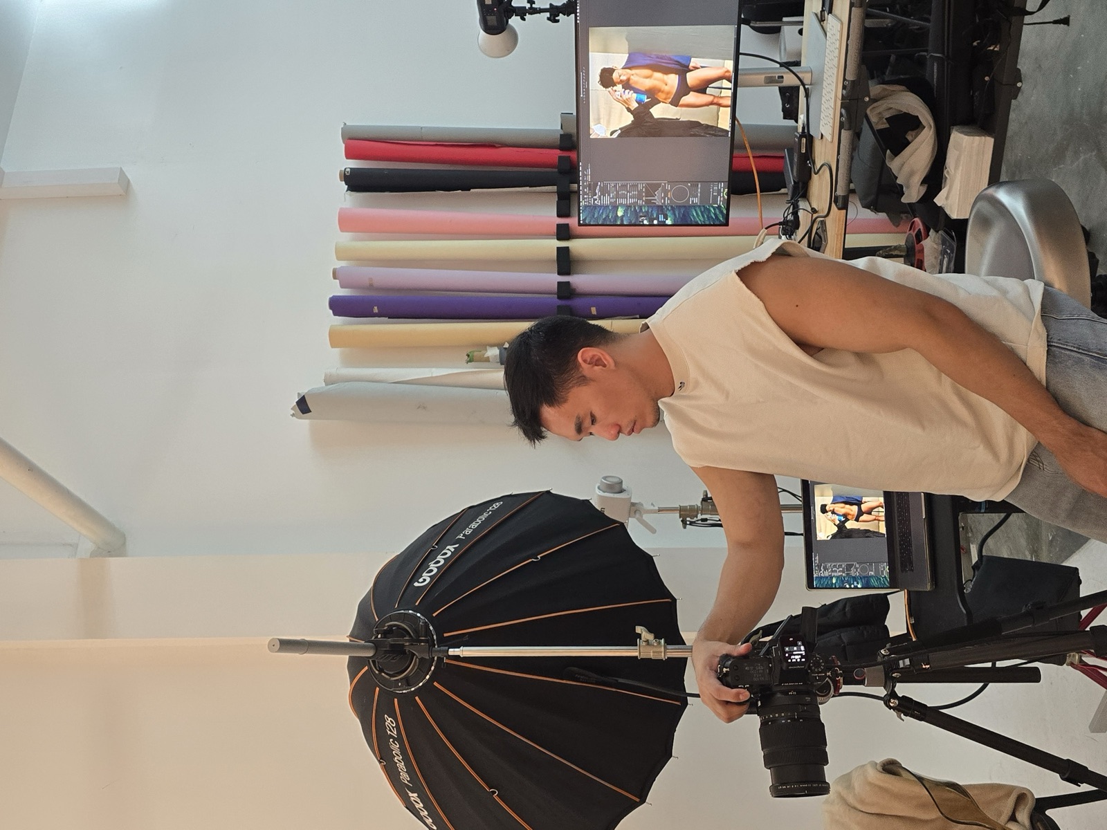 Photographer with Godox setup, backdrop rolls behind